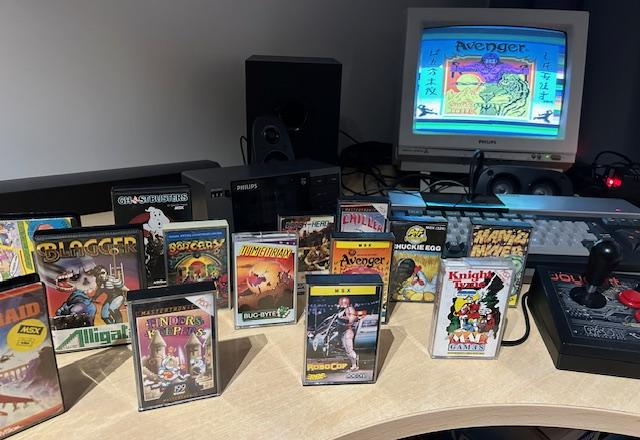 Kolekcja gier MSX w pudełkach na biurku z monitorem