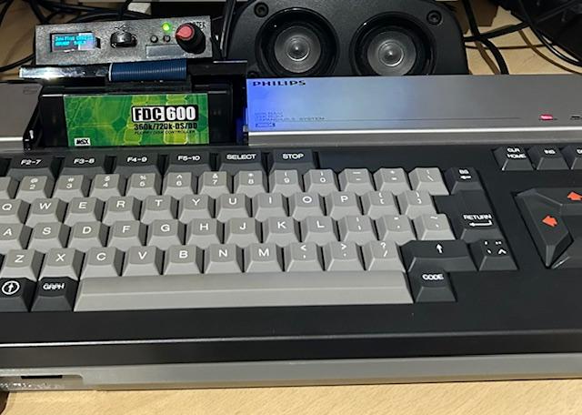 Komputer MSX z monitorem wyświetlającym grę i głośnikami