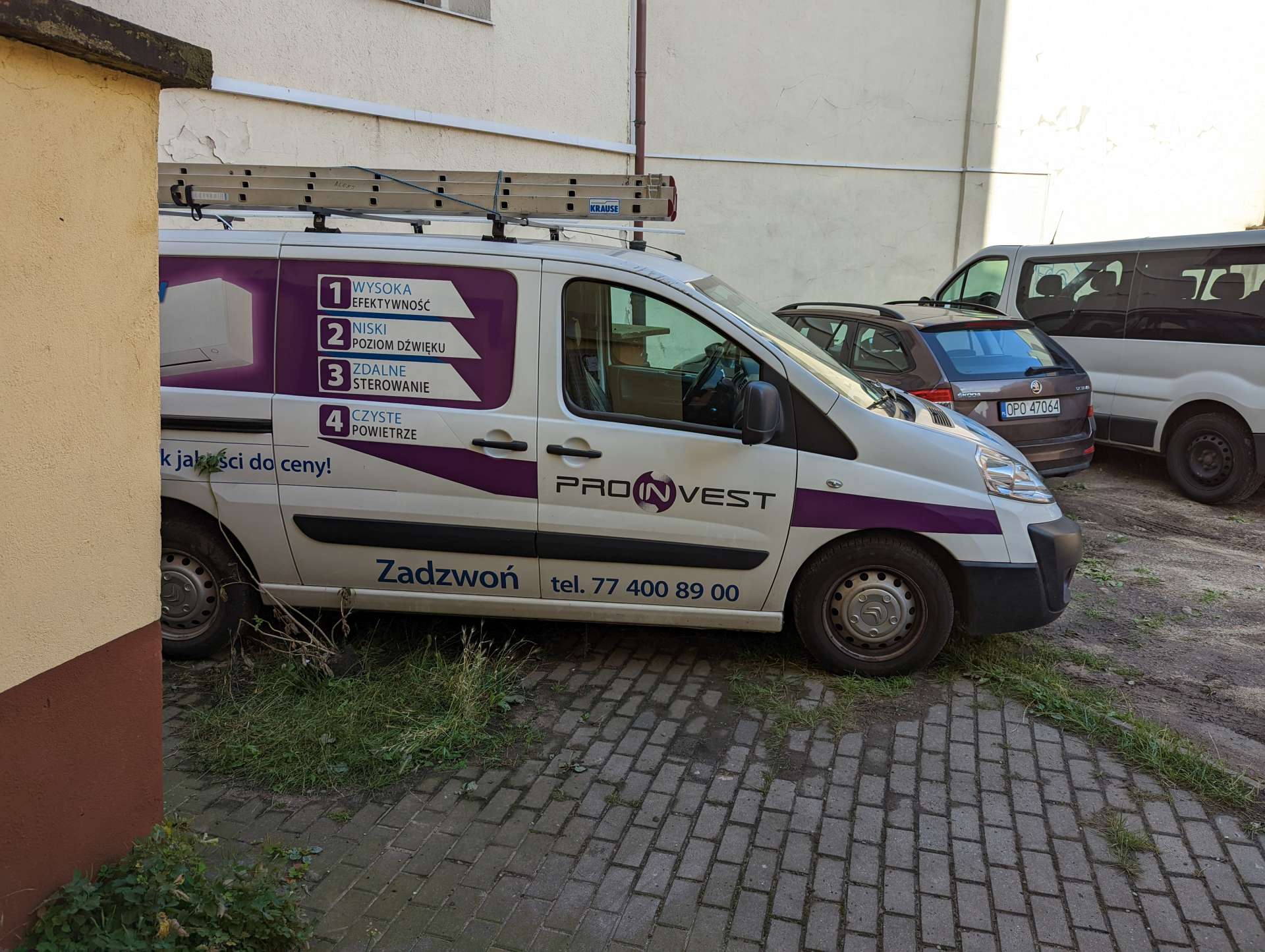 Firmowy van na kocich łbach przy budynku